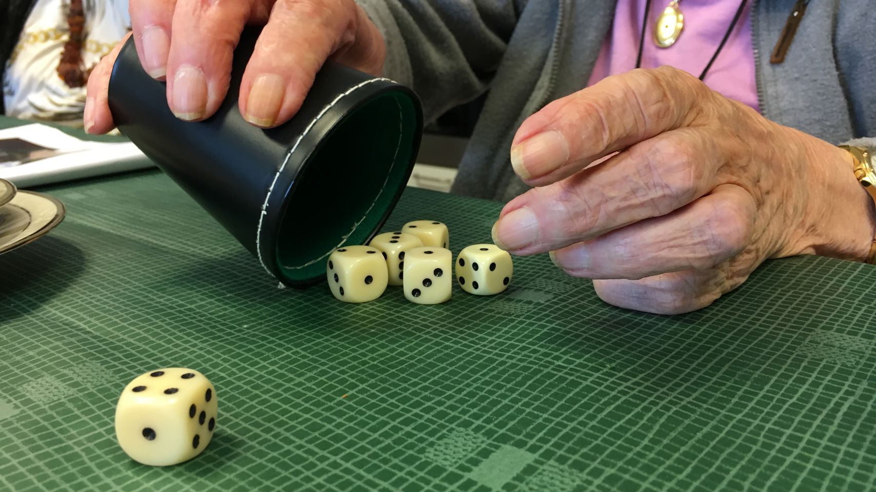 En ældre dame spiller yatzy på Plejecenter Trekroner. Hun har slået 1, 2, 3, 4 og mangler kun en femmer.