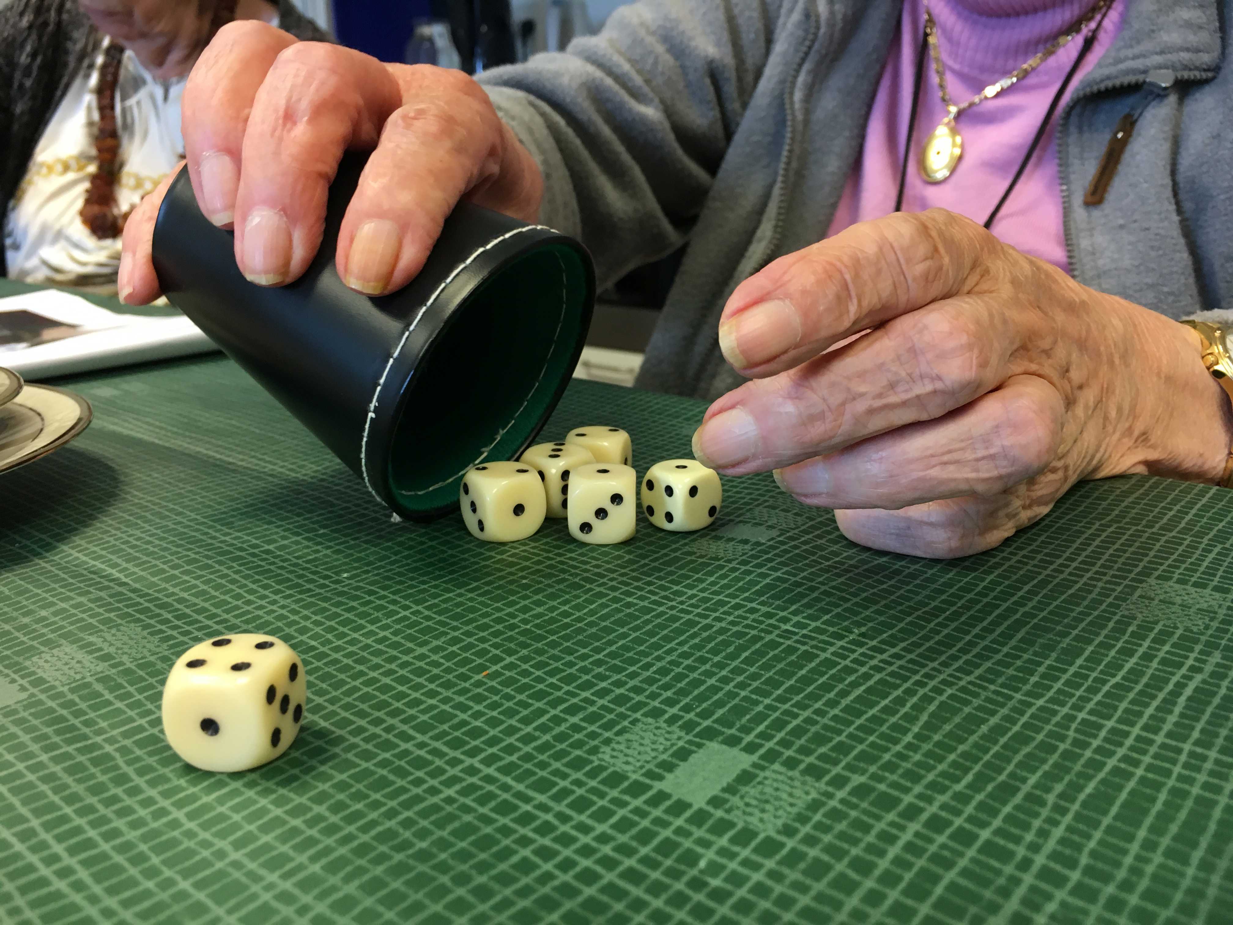 En ældre dame spiller yatzy på Plejecenter Trekroner. Hun har slået 1, 2, 3, 4 og mangler kun en femmer.